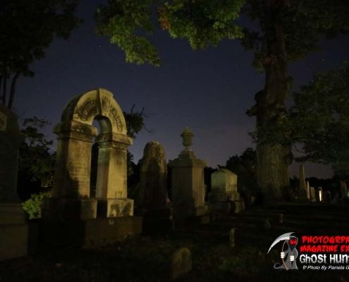 Paranormal investigation Photographing in front of a bunch of headstones with purple skies.