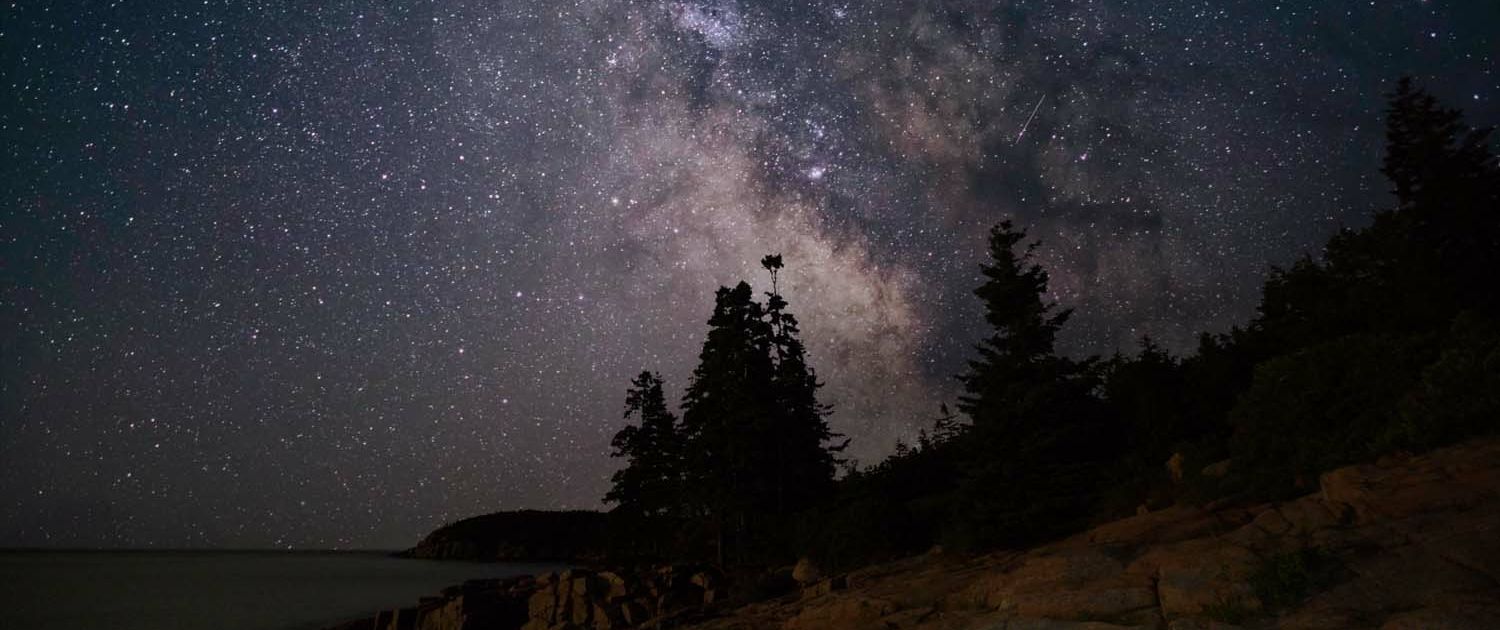 115 Acadia National Park Thunder Hole Milky Way on the side of the water with the trees.