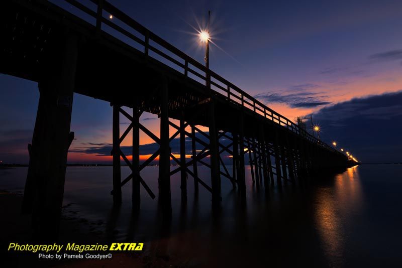 Keansburg NJ fishing pier at night with the lights and the sunset.