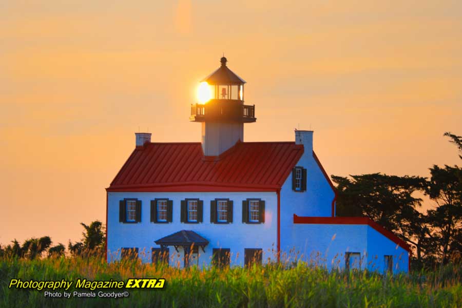 East Point Lighthouse with the sun right at the tip of the lighthouse during sunset.