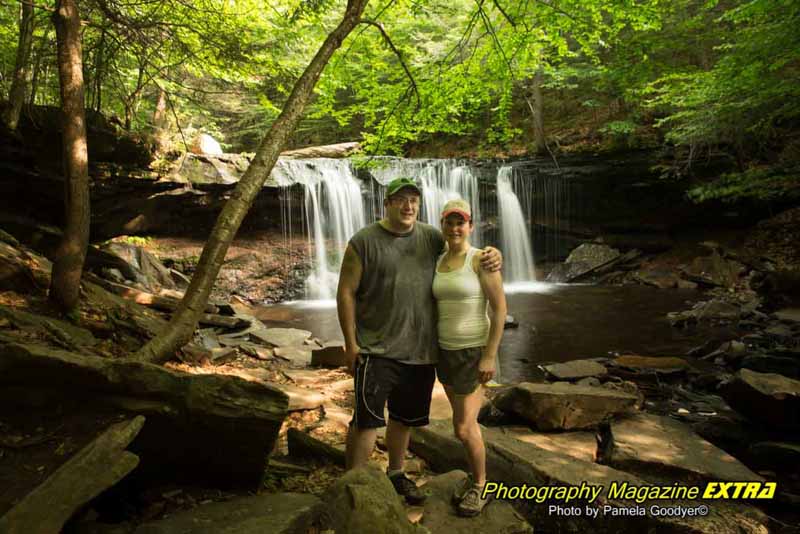 Ricketts Glen State Park freinds by waterfall Two people posing in front of the waterfall in their hiking gear.
